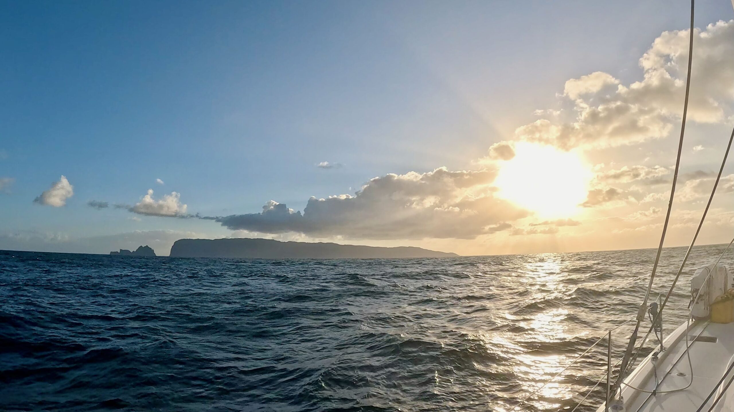 Hazy, angular island shapes on the horizon ahead of the boat.